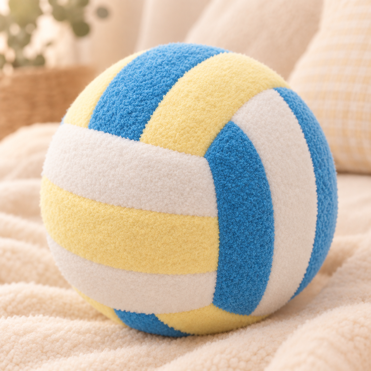 Yellow and blue VolleyPlush plush volleyball on a cozy cream blanket