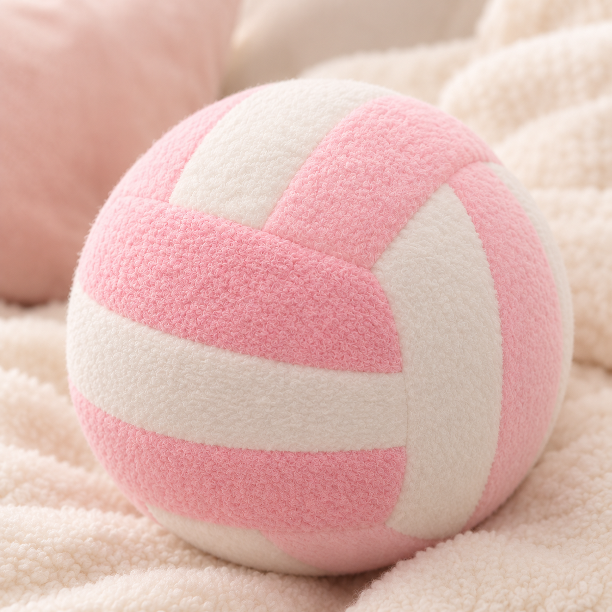 Pink VolleyPlush plush volleyball on a cozy cream blanket
